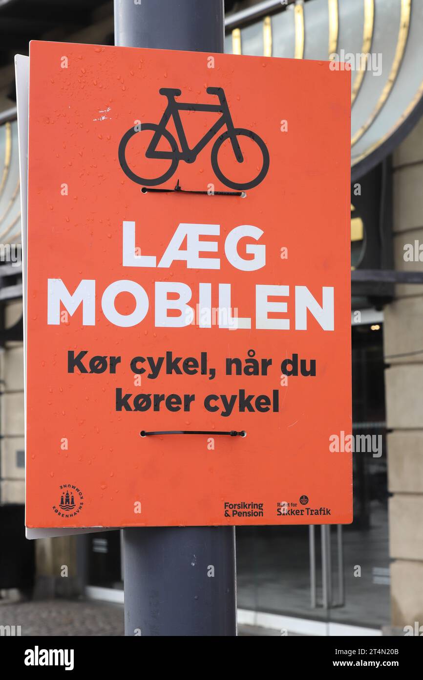 Copenaghen, Danimarca - 22 ottobre 2023: Cartellone fuori dalla stazione centrale con una campagna di sicurezza stradale in danese che esorta a "mettere giù il telefono. Cavalcare Foto Stock