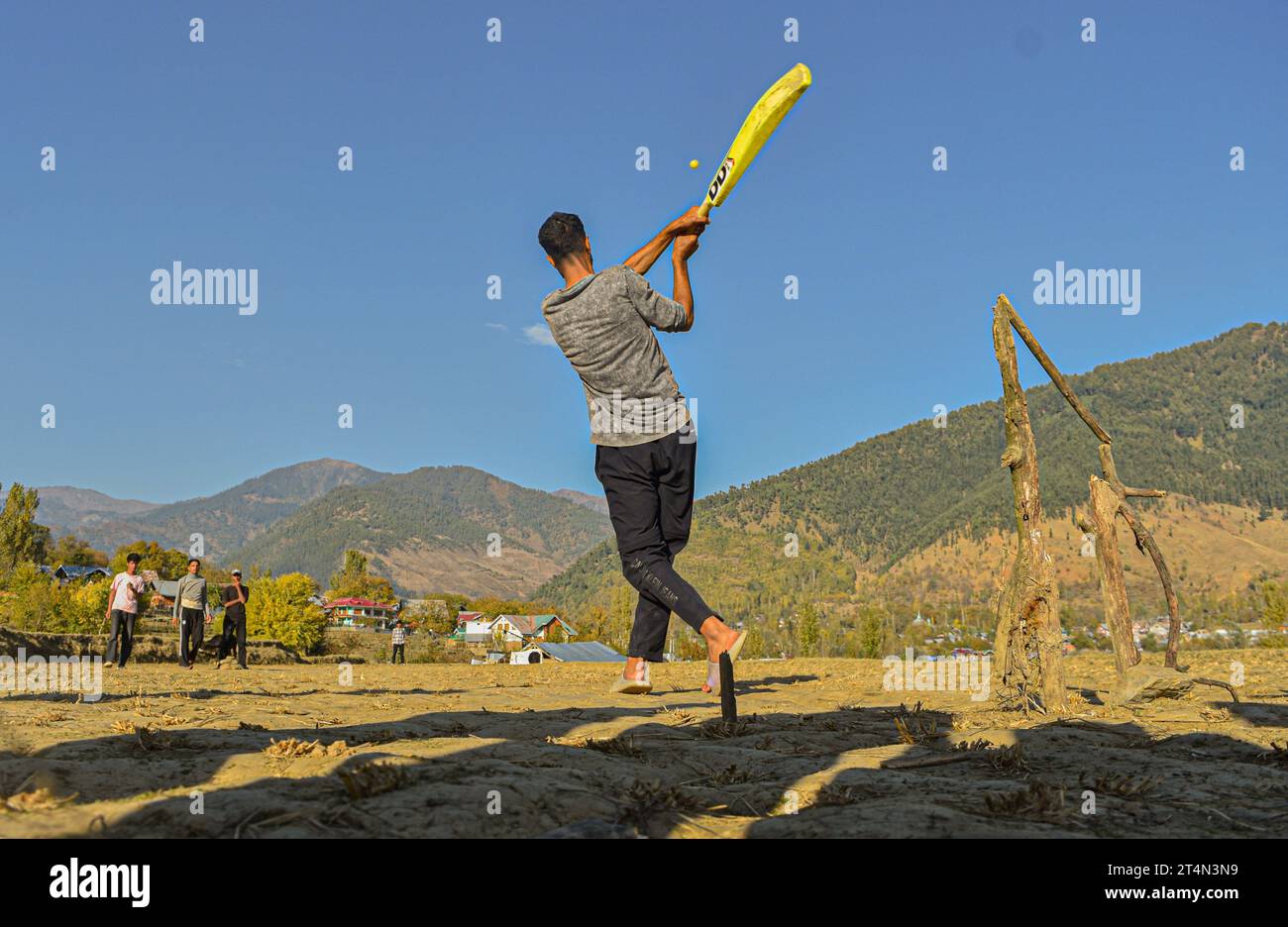 Srinagar, India. 27 ottobre 2023. La gente ama giocare a cricket sulla distesa dorata dei campi di riso raccolti nel distretto di Kupwara nel Kashmir settentrionale, in India, il 27 ottobre 2023. (Foto di Arsalan Ashiq/INA Photo Agency/Sipa USA) credito: SIPA USA/Alamy Live News Foto Stock