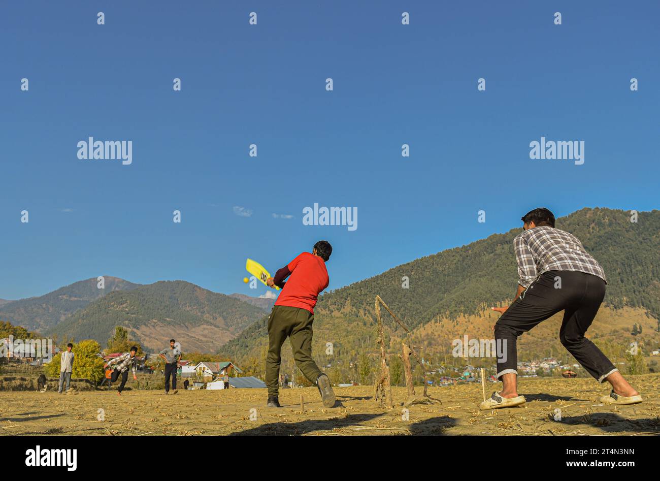 Srinagar, India. 26 ottobre 2023. La gente ama giocare a cricket sulla distesa dorata dei campi di riso raccolti nel distretto di Kupwara nel Kashmir settentrionale, in India, il 27 ottobre 2023. (Foto di Arsalan Ashiq/INA Photo Agency/Sipa USA) credito: SIPA USA/Alamy Live News Foto Stock