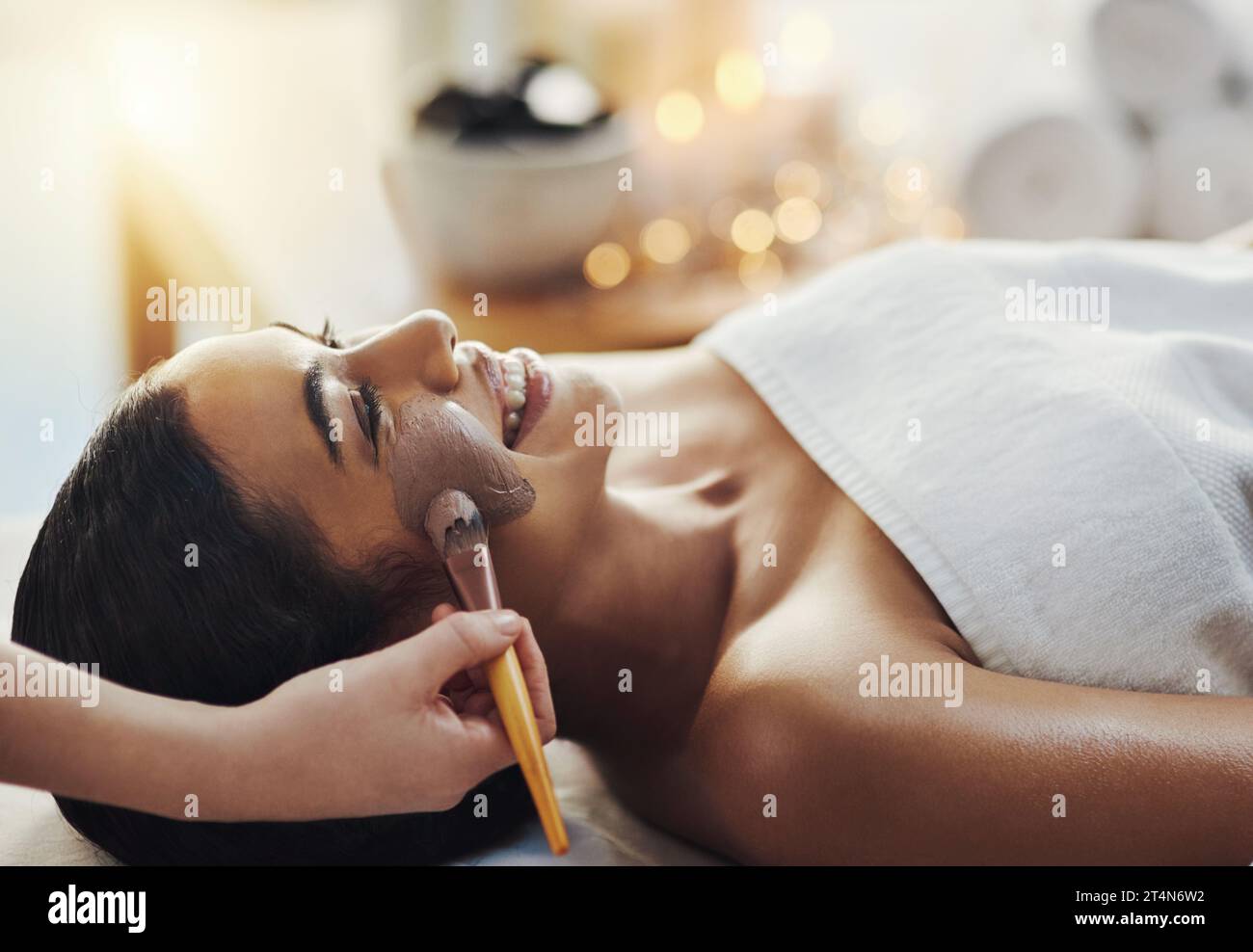Bene, le conceda il trattamento reale completo. una giovane donna che riceve un trattamento facciale in una spa. Foto Stock