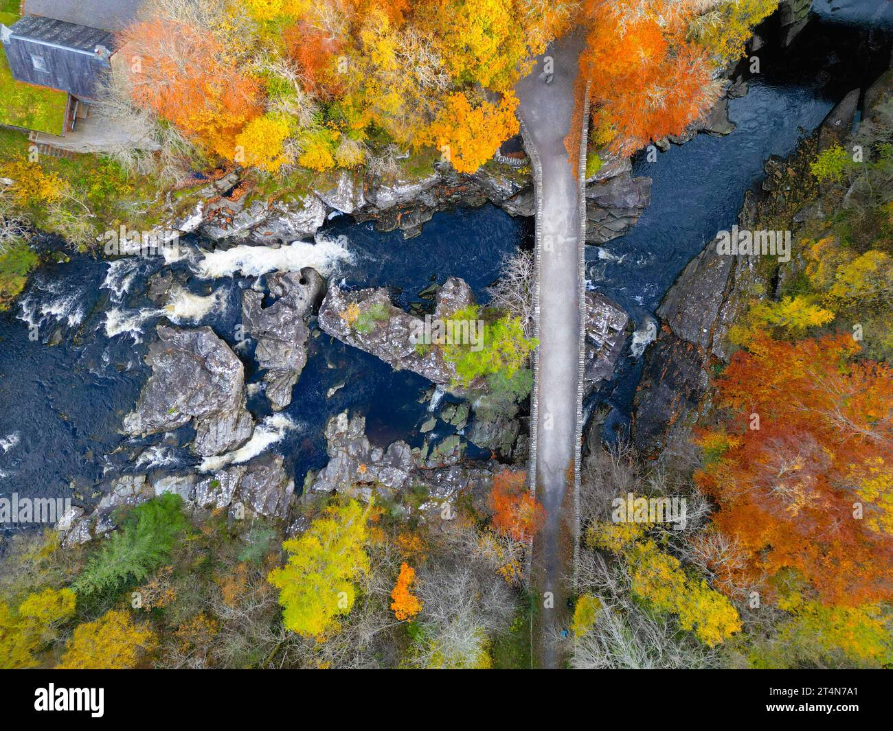 Vista aerea del vecchio ponte che attraversa il fiume Moriston, circondato da boschi dai colori autunnali a Invermoriston, Scozia, Regno Unito Foto Stock