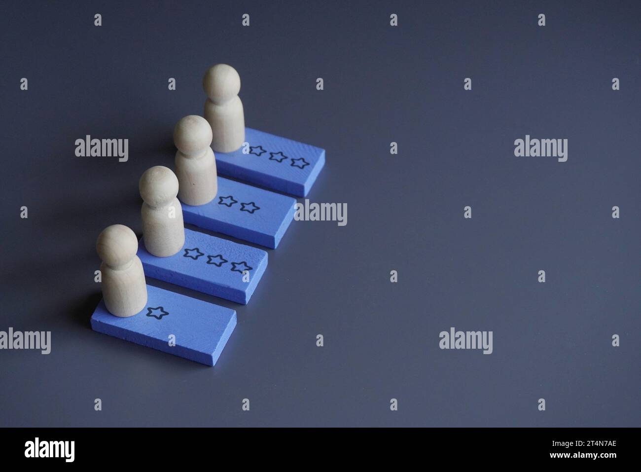 Bambole di legno e icona di revisione a stella. Spazio di copia per il testo. Valutazione dei dipendenti, concetto di performance e progresso Foto Stock
