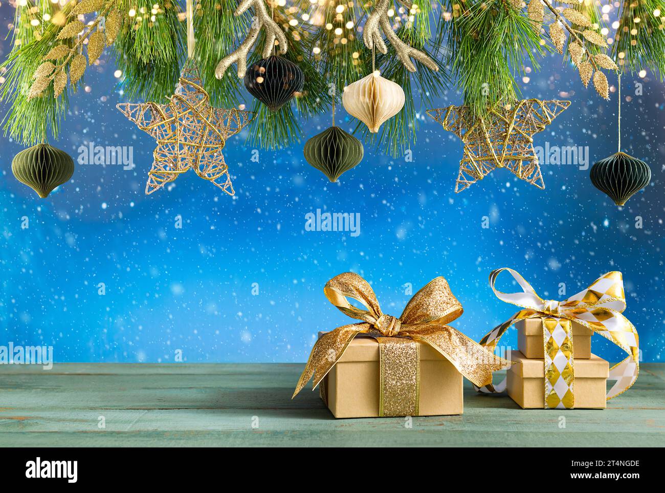 Composizione natalizia o di Capodanno. Rami di abete, decorazioni natalizie dorate e confezioni regalo su tavolo di legno. Foto Stock