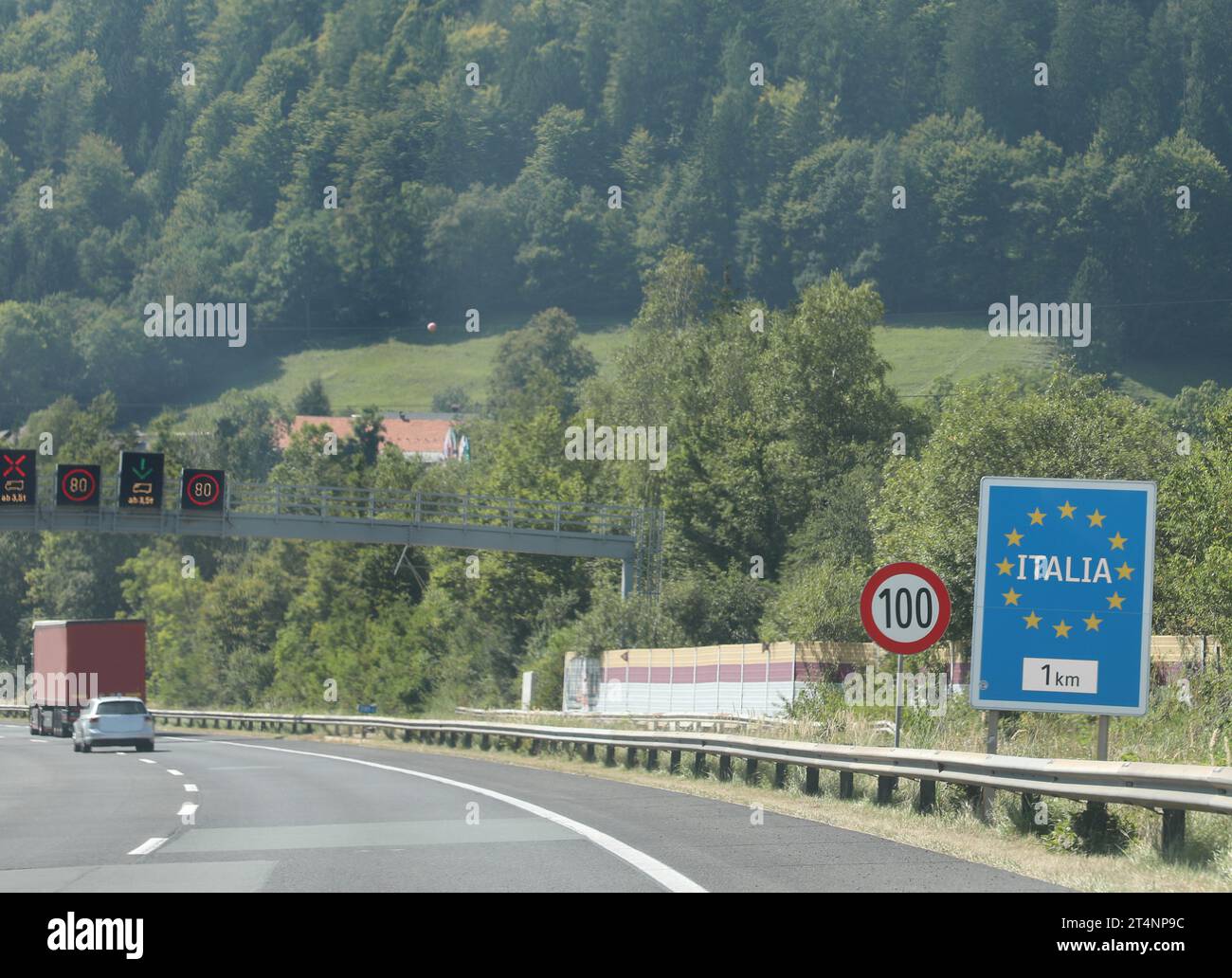 Cartello stradale con il testo ITALIA htat significa ITALIA e stelle europee gialle vicino al confine in montagna Foto Stock