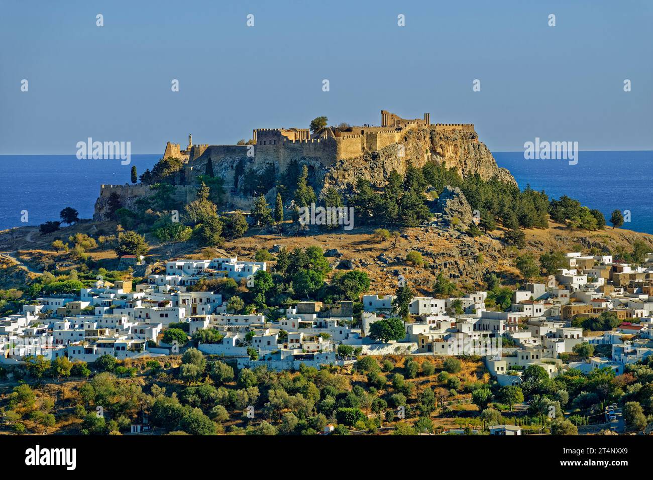 La città di Lindos sull'isola di Rodi con l'Acropoli di Lindos sul suo sito sopraelevato. Foto Stock