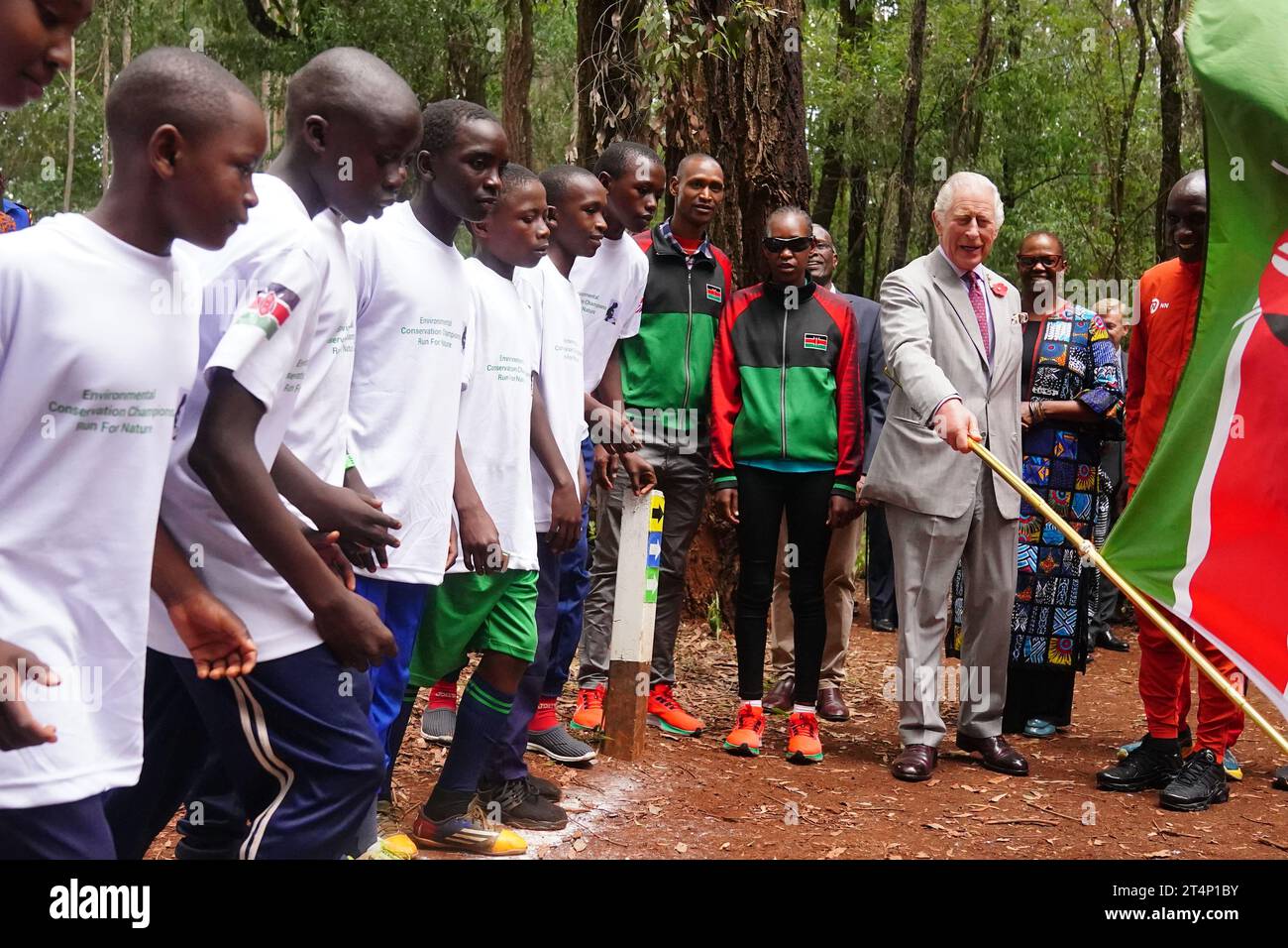 Re Carlo III e maratoneta keniota Eliud Kipchoge (a destra) sventolano i bambini delle scuole che partecipano a un evento di corsa per la natura di 15 km durante una visita alla foresta urbana di Karura a Nairobi per evidenziare il ruolo cruciale degli spazi verdi e delle foreste nelle città sostenibili, il secondo giorno della visita di stato in Kenya. Data foto: Mercoledì 1 novembre 2023. Foto Stock