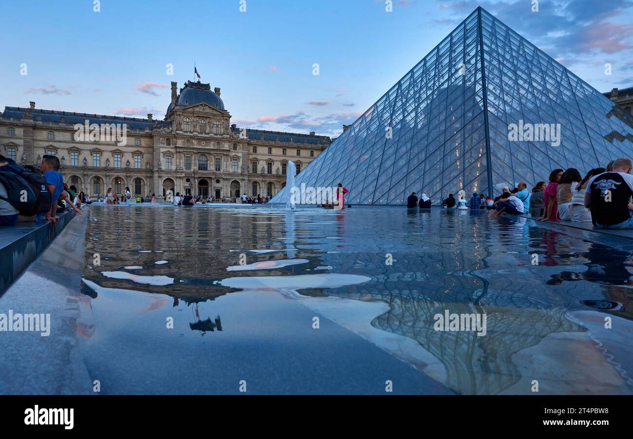 Ammira le piramidi di vetro del palazzo del Louvre al tramonto Foto Stock