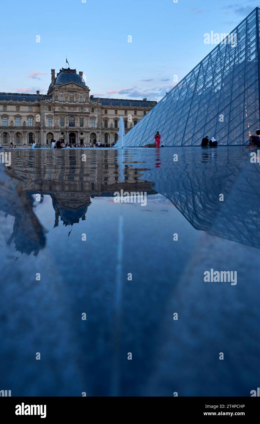 Ammira le piramidi di vetro del palazzo del Louvre al tramonto Foto Stock