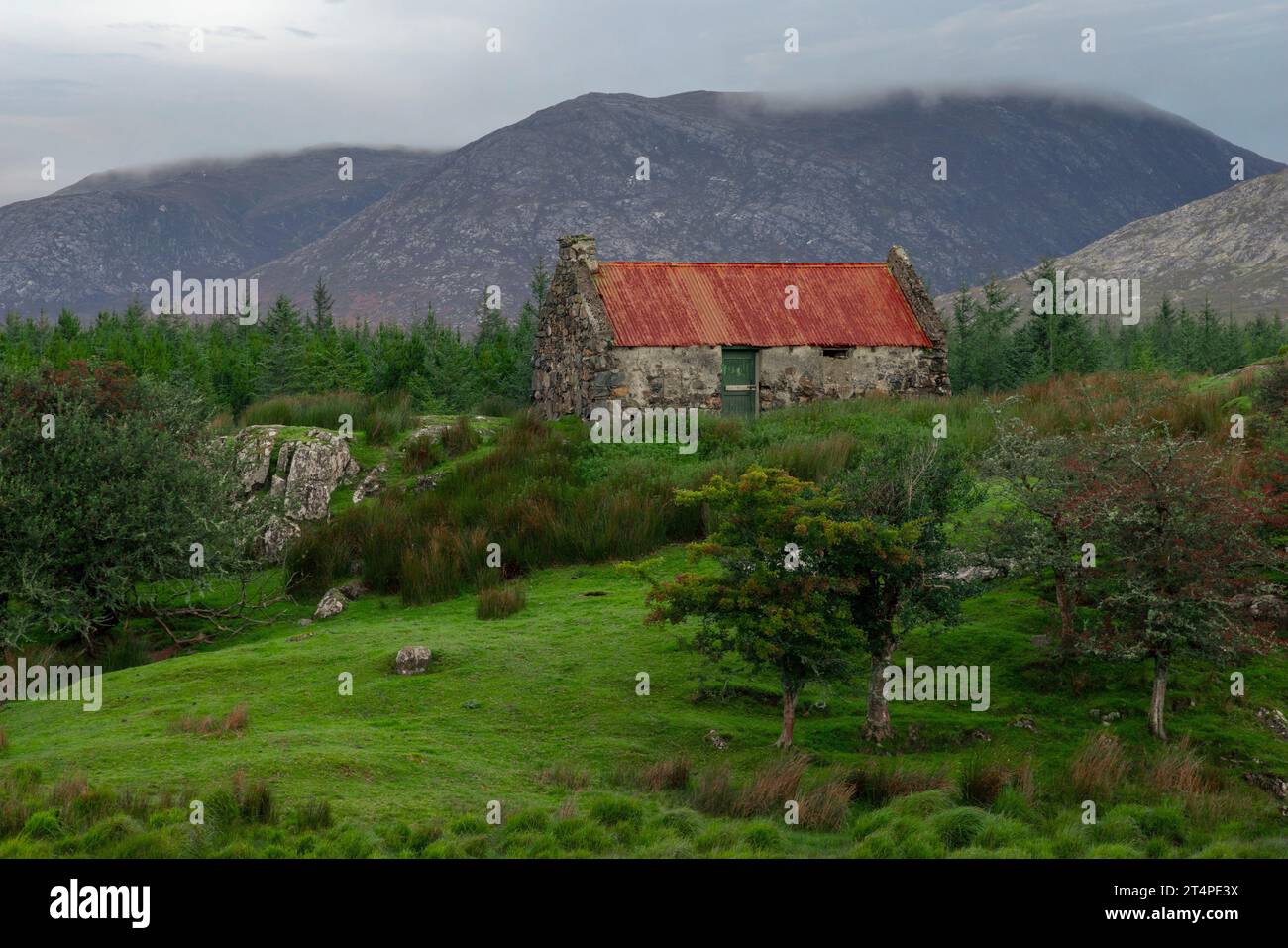 Un vecchio cottage sul tetto di latta arrugginito vicino a Maam Cross, Connemara, Galway, Irlanda. Foto Stock