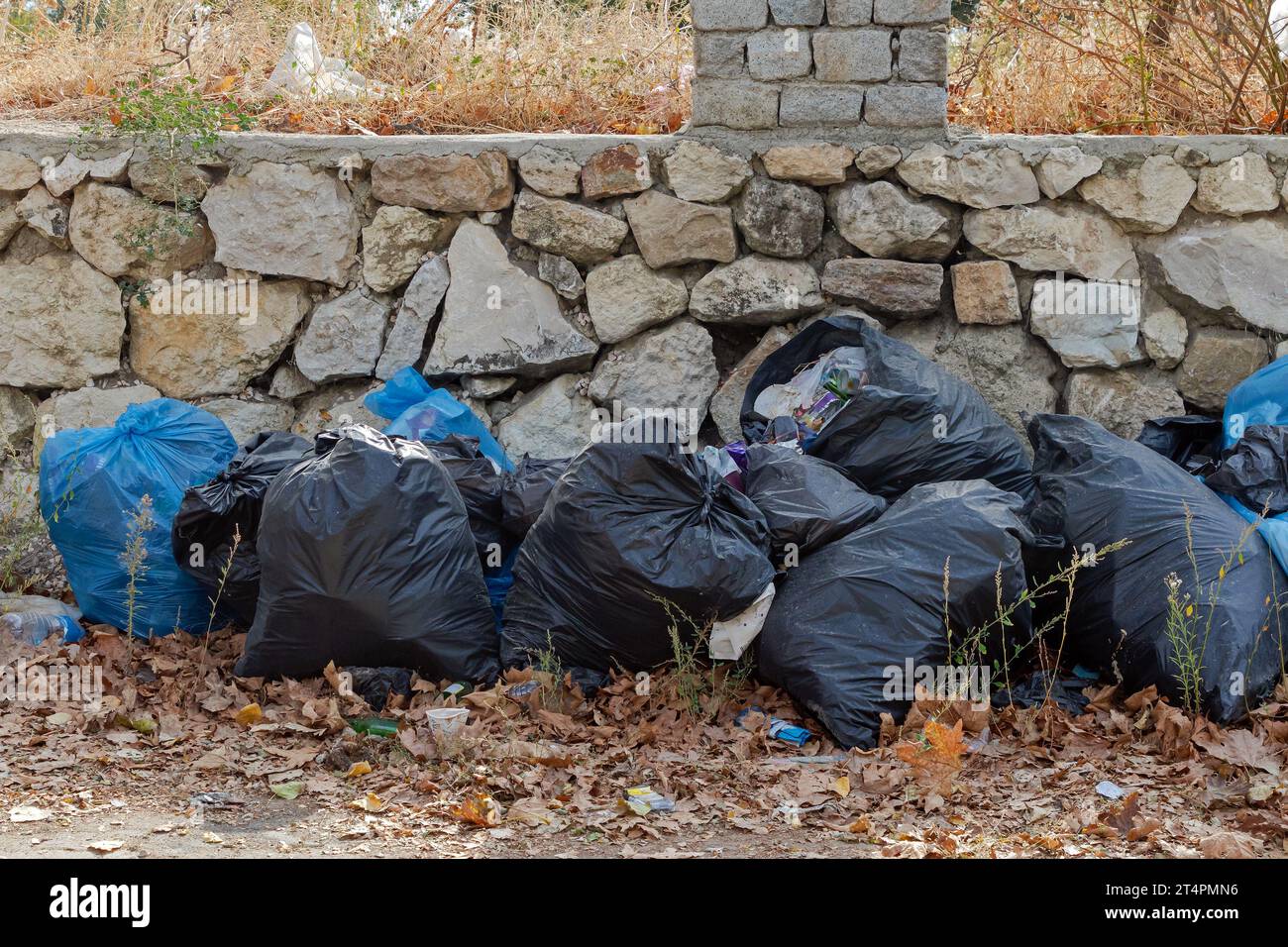 Un mucchio di sacchetti di plastica lasciati fuori sulla strada inquinando l'ambiente Foto Stock