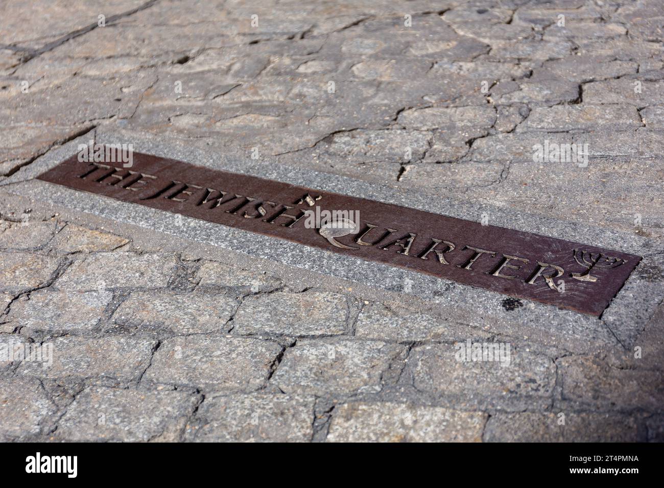 Il cartello metallico del quartiere ebraico sulla strada acciottolata di Toledo, Spagna. Vista ravvicinata, che indica i confini del quartiere ebraico. Foto Stock