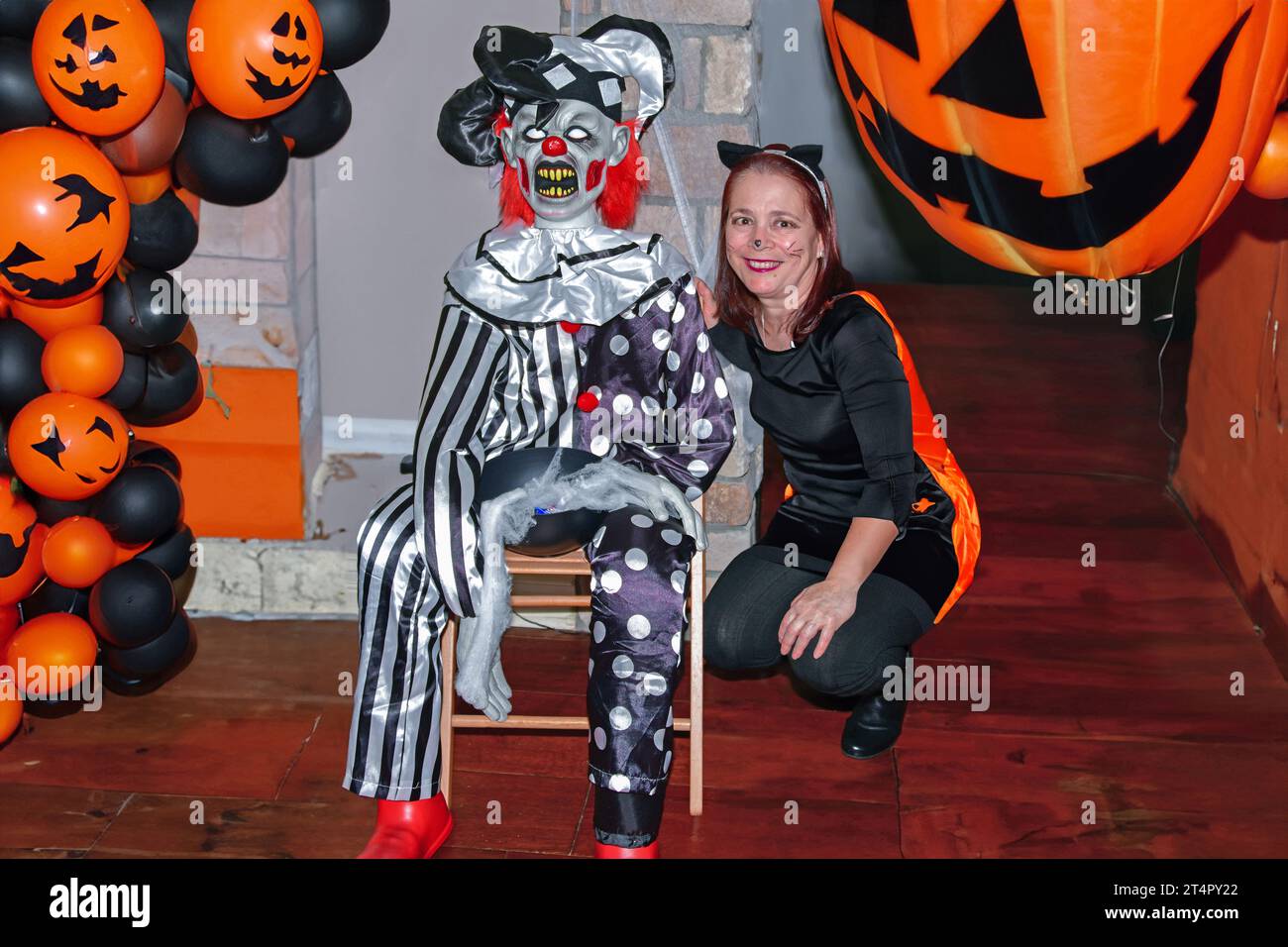 Louisville, Kentucky USA, 26 ottobre 2019, la bella signora posa accanto a un diabolico clown come parte delle festività di Halloween Foto Stock