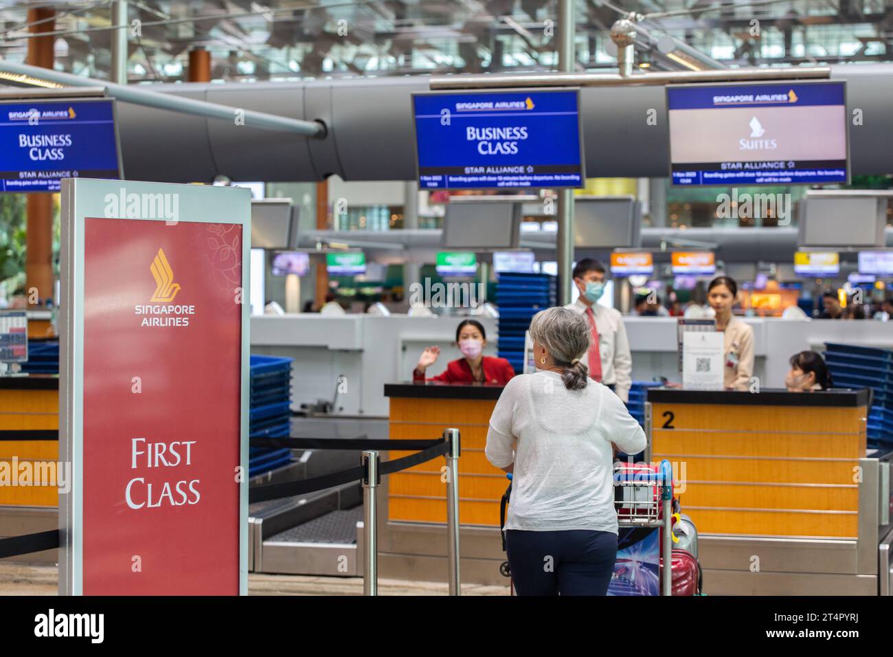 Una donna sta effettuando il check-in per Singapore Airline, costoso volo di prima classe. Foto Stock