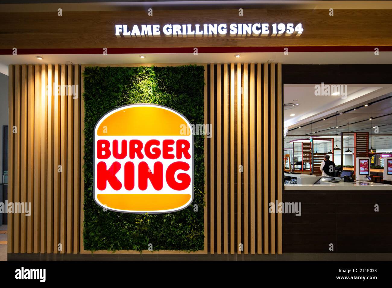 Esterno del marchio del ristorante Burger King, logo ed etichetta al Terminal 4 dell'Aeroporto Changi di Singapore. Catena internazionale di fast food. Foto Stock
