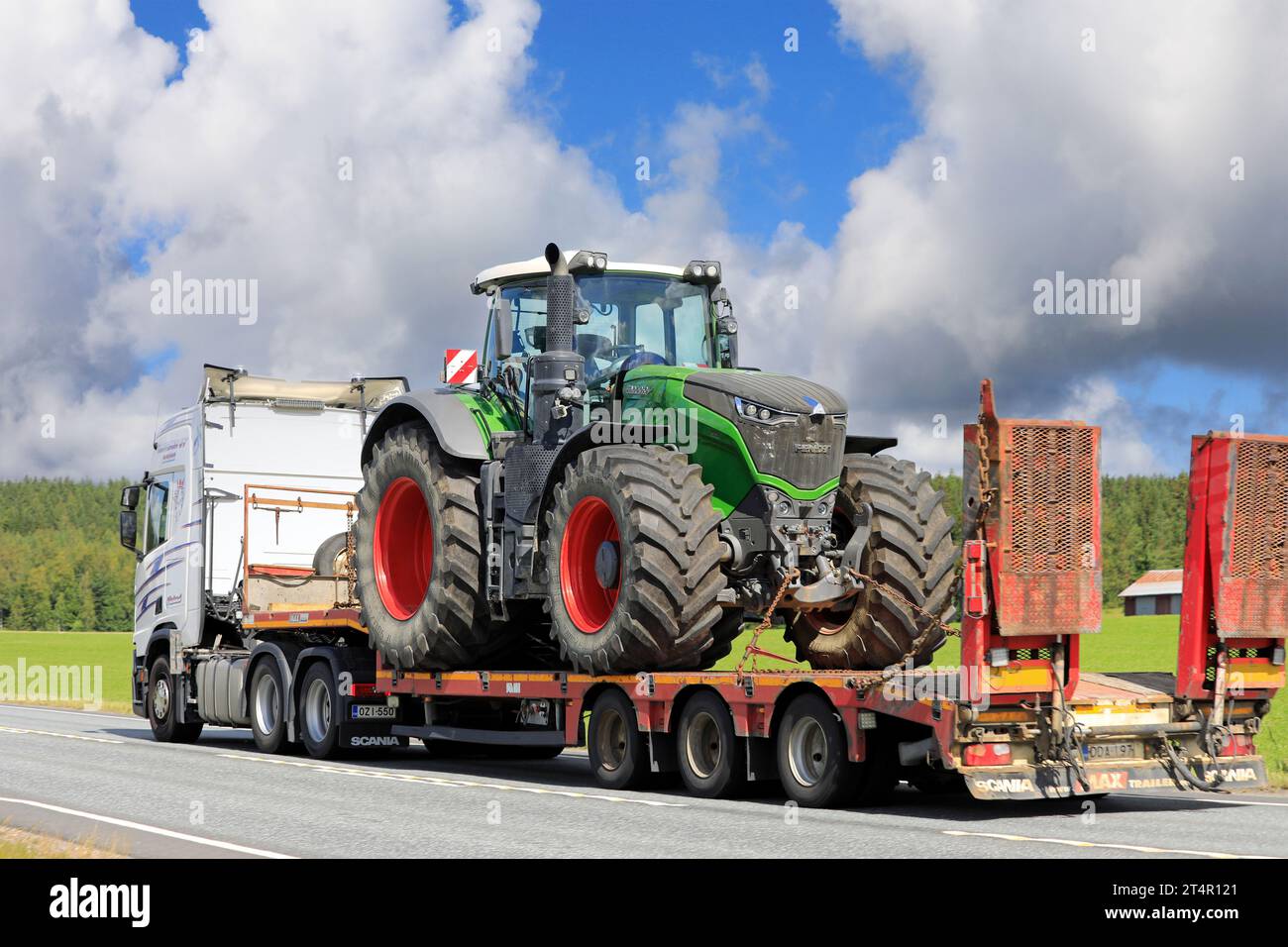 Trasporto del trattore Fendt 1050 Vario su rimorchio con pianale ribassato trainato da autocarro, vista posteriore. Concentrarsi sul trattore. Jokioinen, Finlandia. 21 luglio 2023. Foto Stock