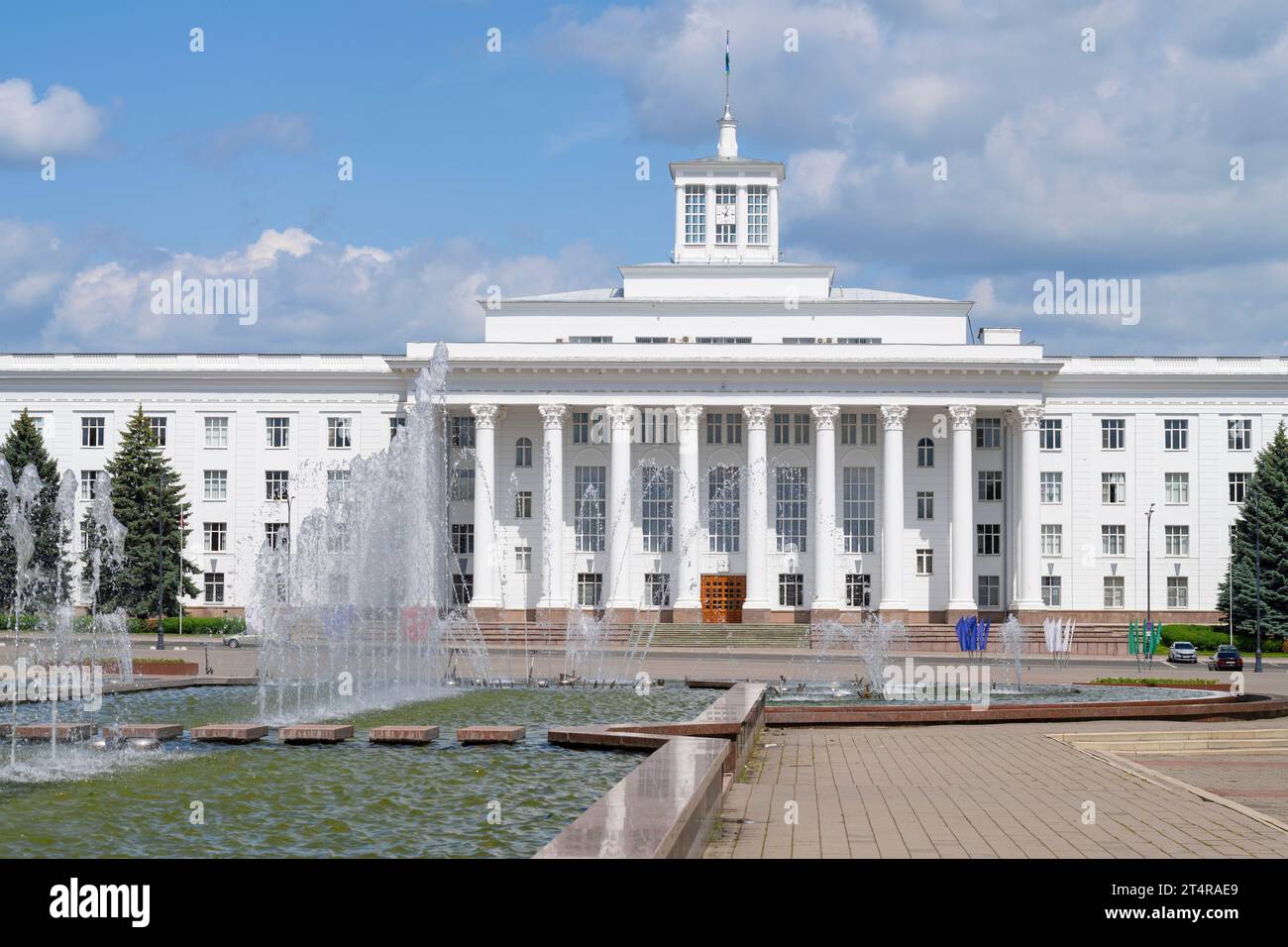 NALCHIK, RUSSIA - 11 GIUGNO 2023: Fontana sullo sfondo della facciata della Casa del governo (Casa Bianca) in un soleggiato giorno di giugno Foto Stock