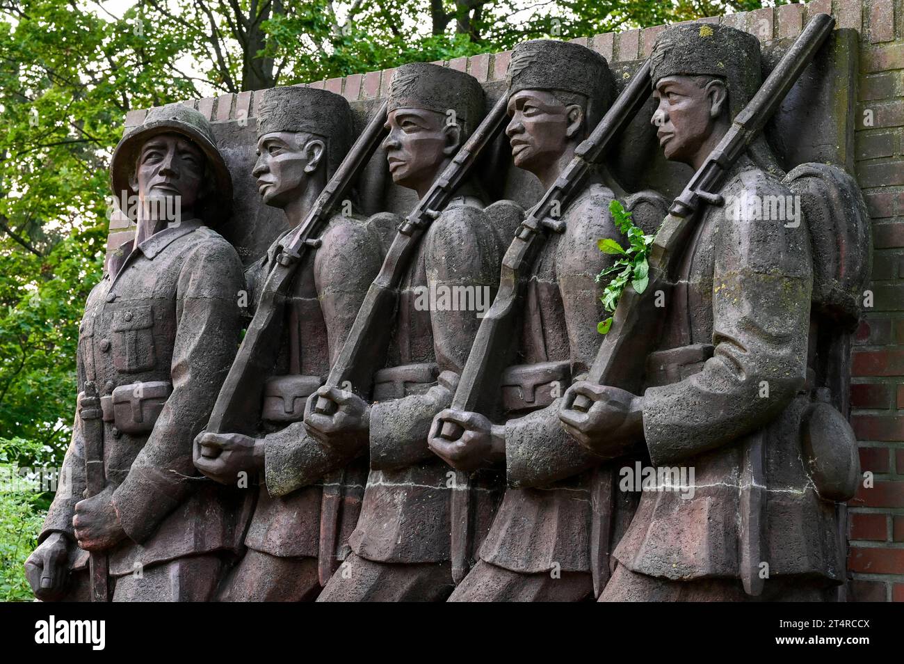 Deutscher Kolonialismus DEUTSCHLAND, Amburgo, Deutsch-Ostafrika-Ehrenmal, Askari Relief im sogenannten Tansania Park auf dem Gelände der ehemaligen Wehrmacht Kaserne Lettow-Vorbeck a Jenfeld, Askari abgeleitet vom Swahili Wort mit arabischem Ursprung für Soldat, Bezeichnung für die Soldat, Soldat in Kolisten en Solden, Polizieiten en en Darstellung eines deutschen Offiziers der Schutztruppe mit ihm folgenden Askaris, Askaris wurden auch im Maji Maji Aufstand gegen die Aufständischen und die Bevölkerung eingesetzt, Relief geschaffen und aufgestellt 1938 von Bildhauer Walter von Rucktesc Foto Stock