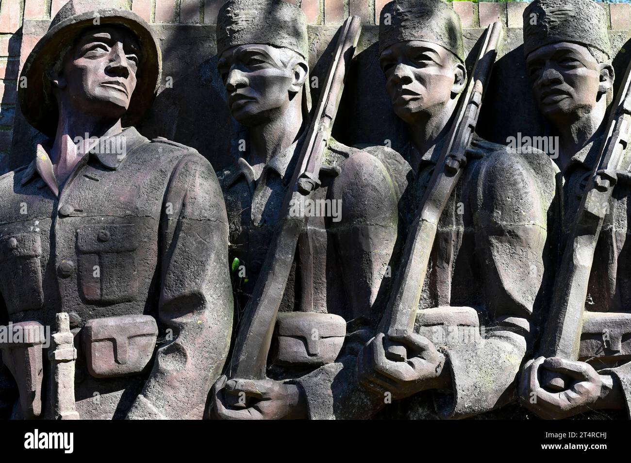 Deutscher Kolonialismus DEUTSCHLAND, Amburgo, Deutsch-Ostafrika-Ehrenmal, Askari Relief im sogenannten Tansania Park auf dem Gelände der ehemaligen Wehrmacht Kaserne Lettow-Vorbeck a Jenfeld, Askari abgeleitet vom Swahili Wort mit arabischem Ursprung für Soldat, Bezeichnung für die Soldat, Soldat in Kolisten en Solden, Polizieiten en en Darstellung eines deutschen Offiziers der Schutztruppe mit ihm folgenden Askaris, Askaris wurden auch im Maji Aufstand 1905-07 gegen die Aufständischen und die Bevölkerung eingesetzt, Relief geschaffen und aufgestellt 1938 von Bildhauer Walter von Foto Stock