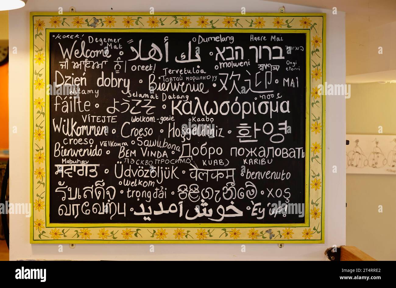 Inghilterra, Yorkshire, Haworth, cartello di benvenuto, scritto in molte lingue diverse nel caffè locale. Foto Stock