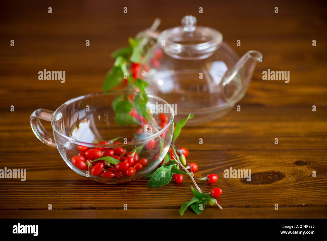 Ramo con bacca di goji rossa matura su un tavolo di legno marrone Foto Stock