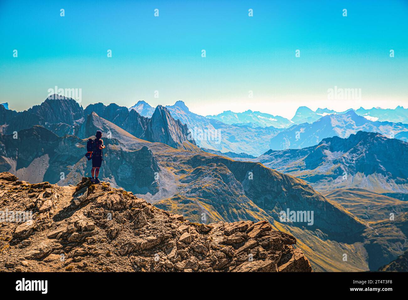 ein Wanderer steht am Gipfel den Mohnefluh im Lechquellengebirge in Österreich und schaut über die Alpen,Lech Östereich Foto Stock