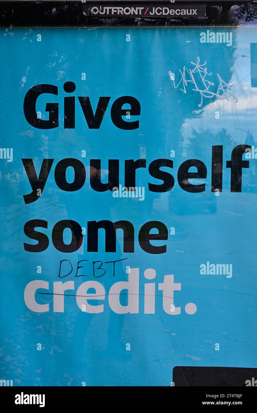 Graffiti modifica del credito in addebito sul poster pubblicitario della fermata dell'autobus. Foto Stock