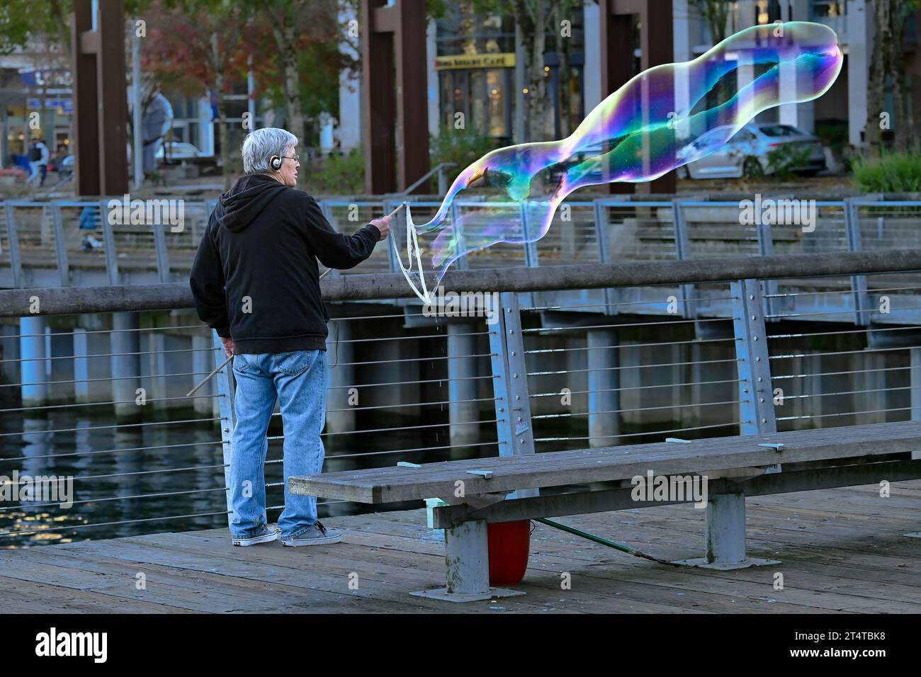 Uomo che produce grandi bolle di sapone, False Creek, Vancouver, British Columbia, Canada Foto Stock