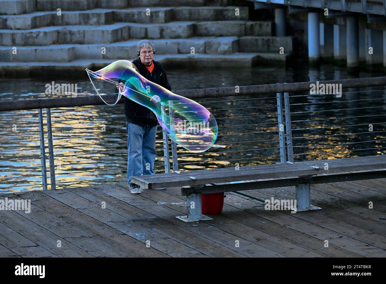 uomo che fa una grande bolla di sapone Foto Stock