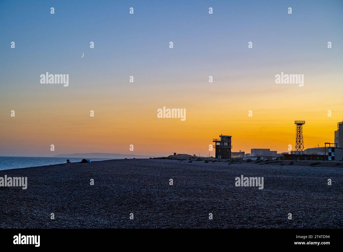 Guardando verso la centrale elettrica di Dungeness al tramonto Foto Stock