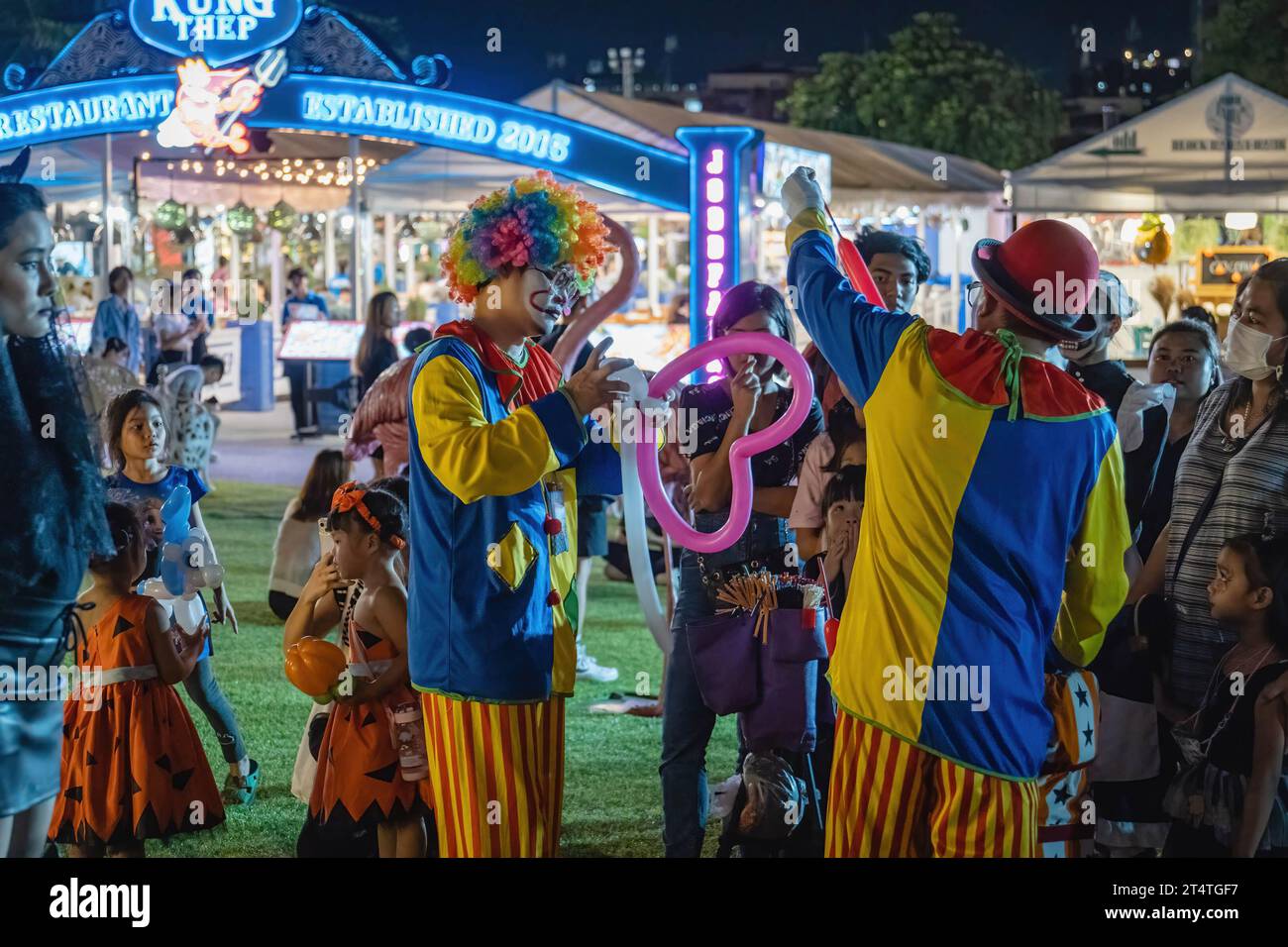 Bangkok, Thailandia. 31 ottobre 2023. I clown offrono palloncini ai bambini durante l'Happy Halloween Festival 2023 alla Jodd Fairs DanNeramit, a Bangkok. Il più famoso mercato notturno di Bangkok, Jodd Fairs, ha recentemente aperto una nuova filiale al DanNeramit, un formale parco a tema con un castello da favola che copre un'area di 52800 metri quadrati con una varietà di bancarelle come vestiti e accessori, oggetti d'epoca, birre artigianali, souvenir, cibo tailandese e internazionale. Credito: SOPA Images Limited/Alamy Live News Foto Stock