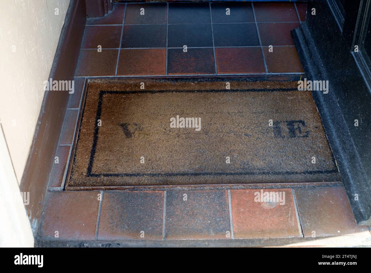 il tappetino con setole vecchie e usate nel concetto di ingresso al pub ha rovinato il tuo benvenuto a portsmouth, inghilterra, regno unito Foto Stock