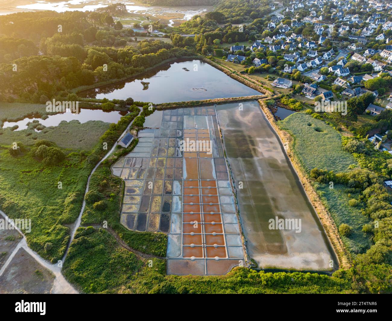 Vista aerea della palude salina di Kervillen con la città di la Trinité-sur-Mer sullo sfondo (Morbihan, Bretagna, Francia). Piccola estrazione artigianale del sale. Foto Stock