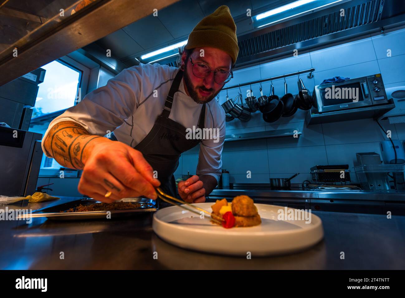 Lo chef Ingo Mark impiatta un piatto di filetto di carpa e zucca nella cucina del ristorante Holzfellas. Wiesau (VGem), Baviera, Germania. Foto Stock