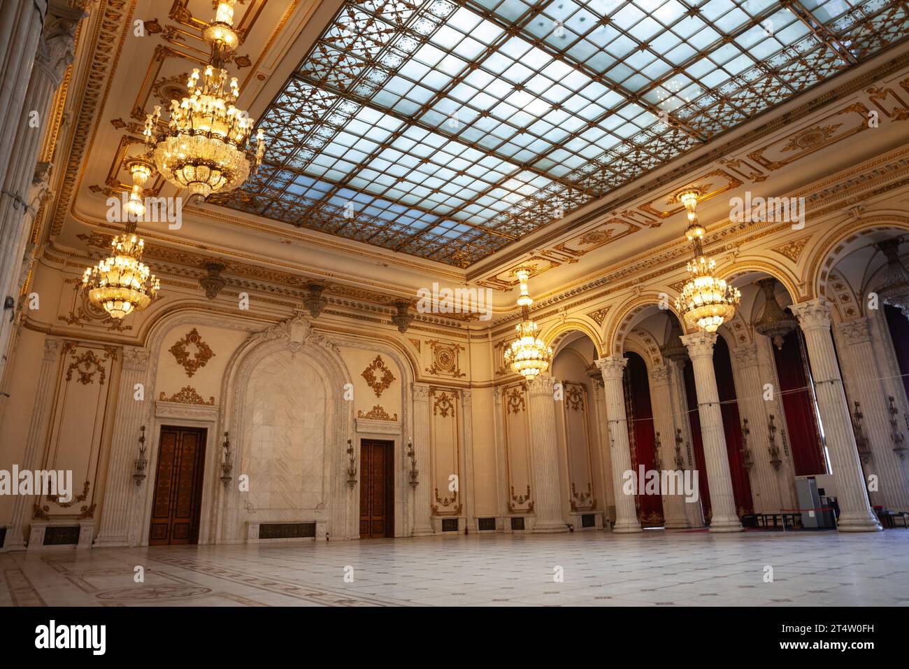 Immagine dell'interno del palazzo del parlamento rumeno, con particolare attenzione alle grandi porte in legno e ai lampadari su una sala di ricevimento. Il Palazzo di Th Foto Stock