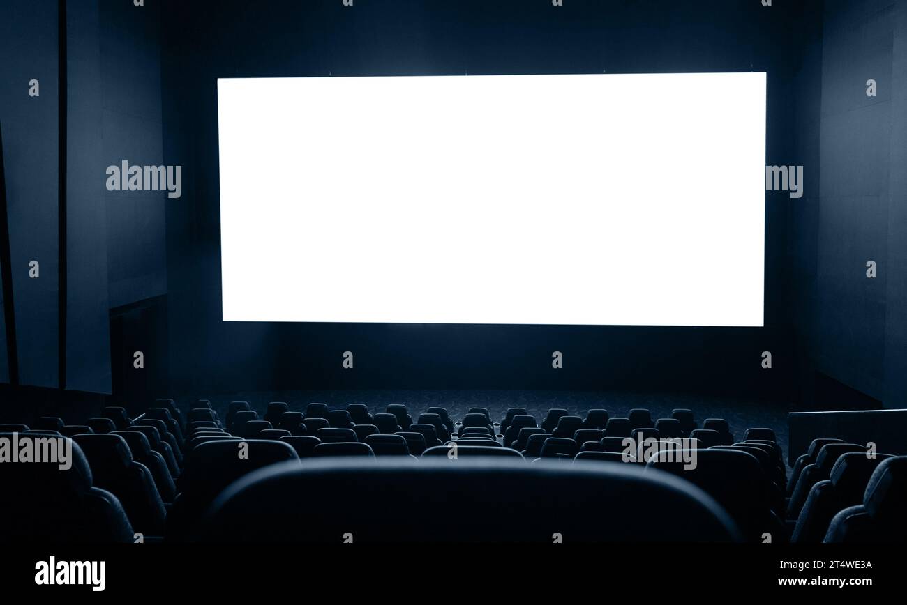 Interni scuri del cinema con schermo e sedie Foto Stock