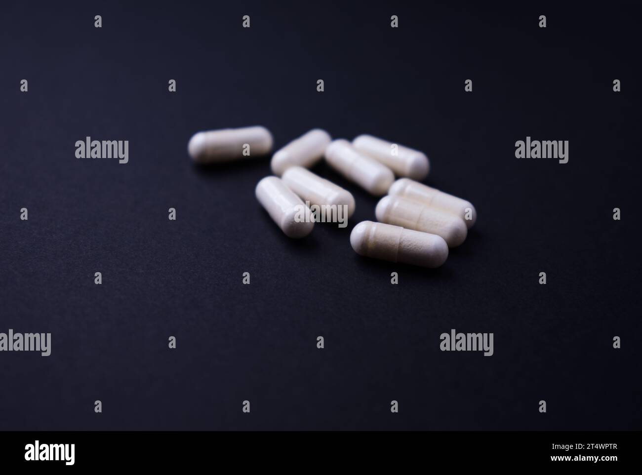 Capsule di arginina alfa-chetoglutarato (AAKG). Integratori alimentari per bodybuilding su fondo di carta scura. Messa a fuoco morbida. Primo piano. Copia spazio. Foto Stock