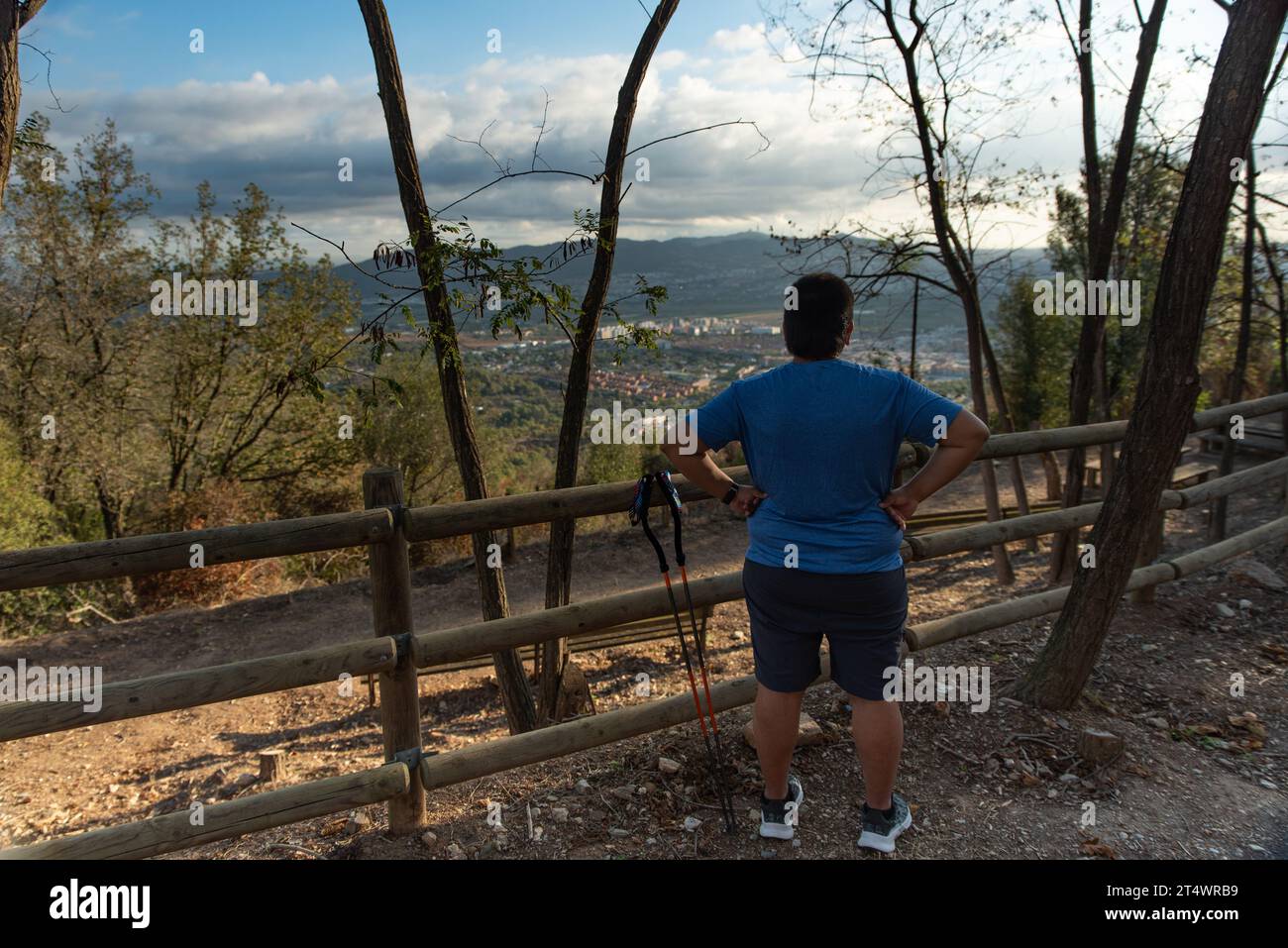 L'uomo in sovrappeso interrompe il suo allenamento per contemplare il paesaggio la mattina. Foto Stock