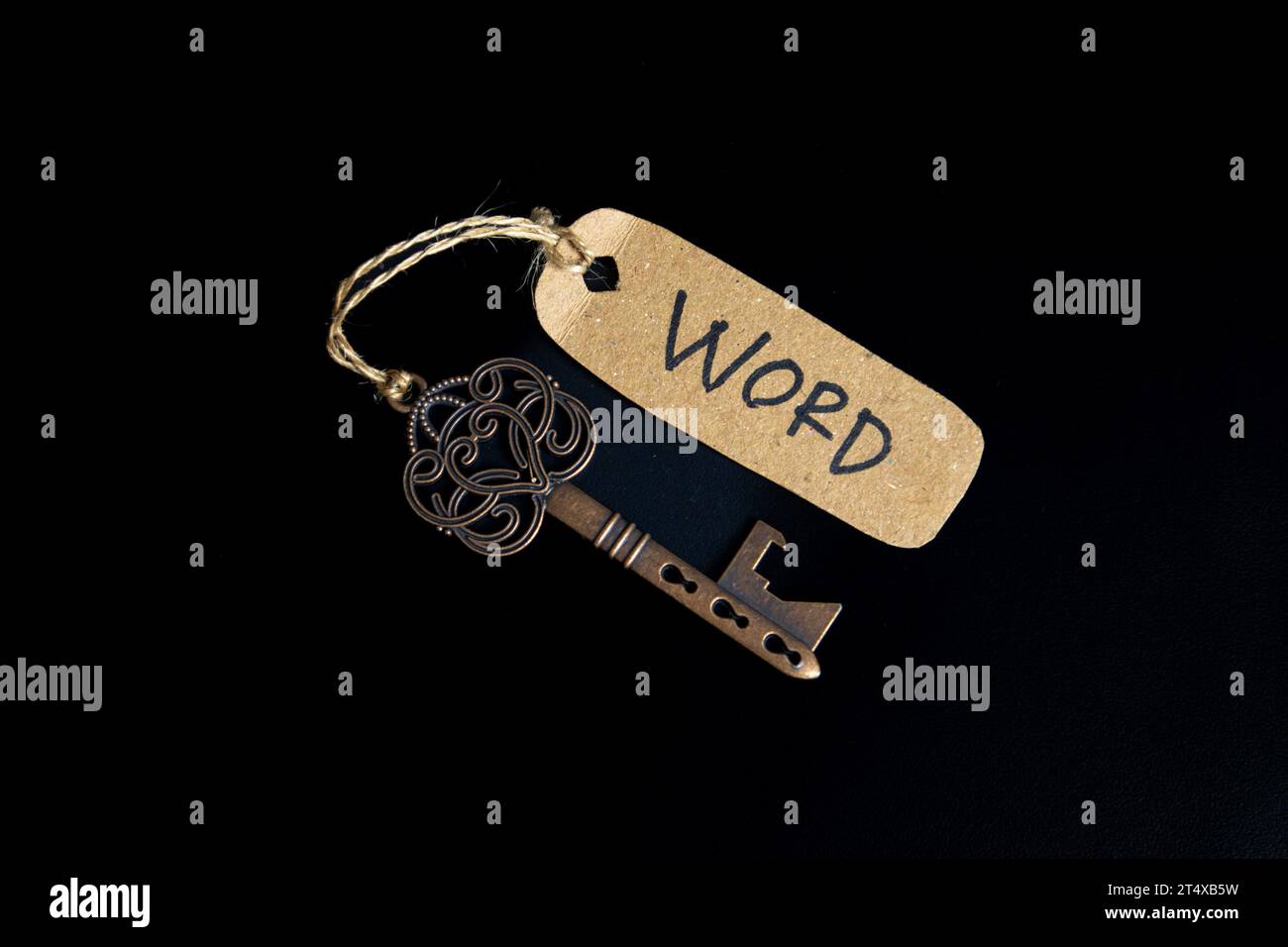 Vecchia chiave antica con tag WORD su sfondo nero Foto Stock