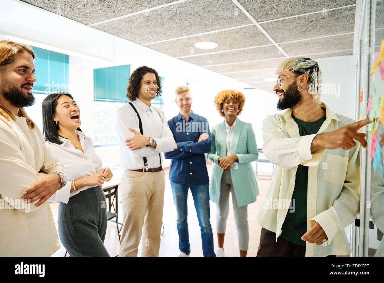 Un giovane che usa i post-it per spiegare le idee in un coworking Foto Stock