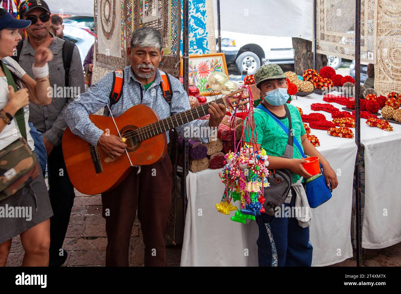 Uomo che suona la chitarra per donazioni al mercato dell'artigianato di Plaza Tenanitla di San Jacinto Square e al Bazar Sabado il sabato d'arte a città del Messico, Messico Foto Stock