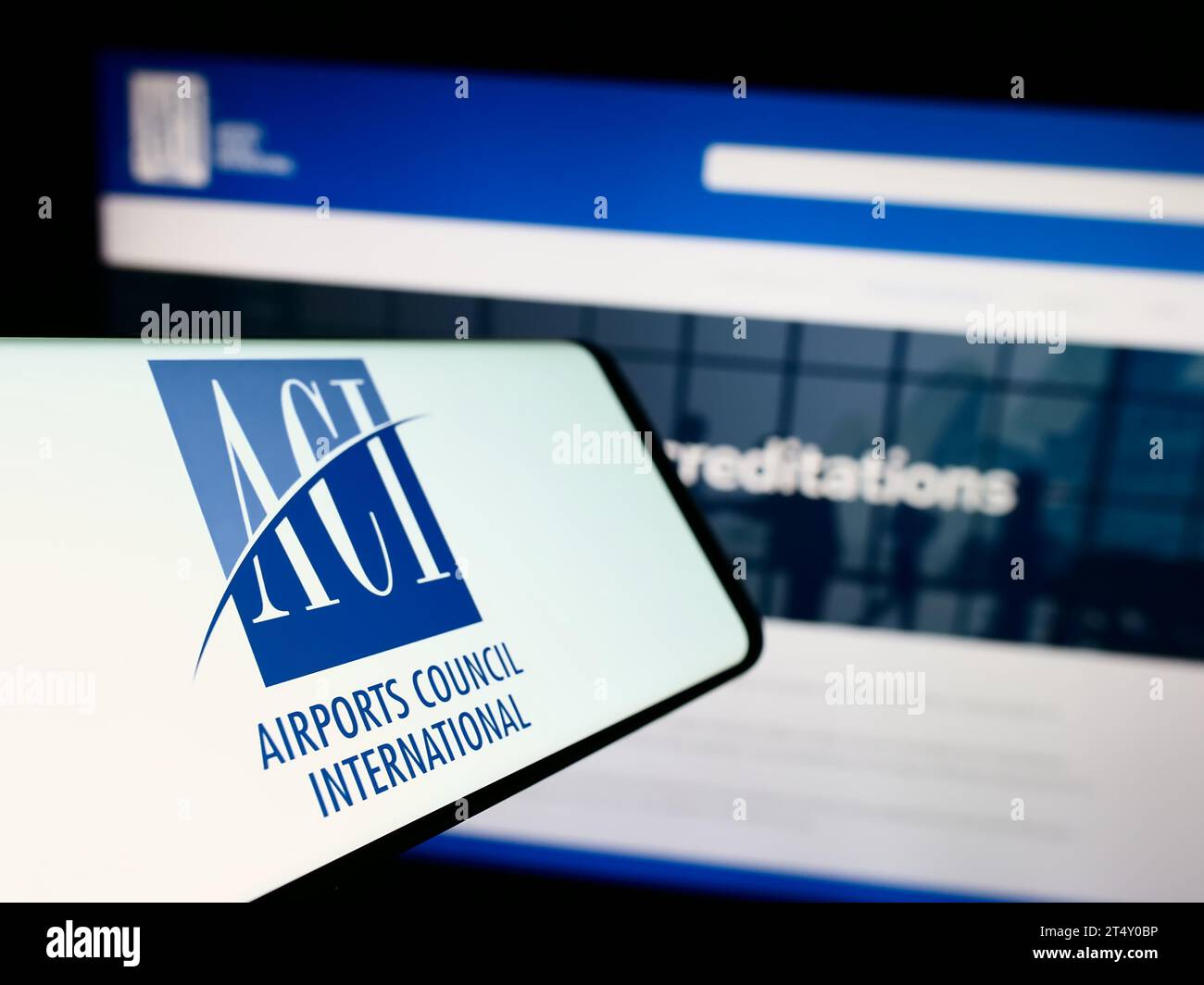 Cellulare con logo dell'organizzazione Airports Council International (ACI) davanti al sito web. Concentrarsi sul centro del display del telefono. Foto Stock
