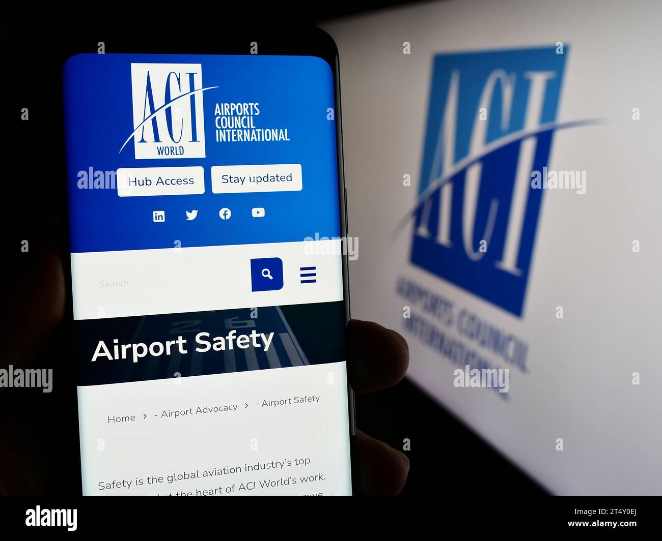 Persona in possesso di cellulare con pagina web dell'organizzazione Airports Council International (ACI) davanti al logo. Concentrarsi sul centro del display del telefono. Foto Stock