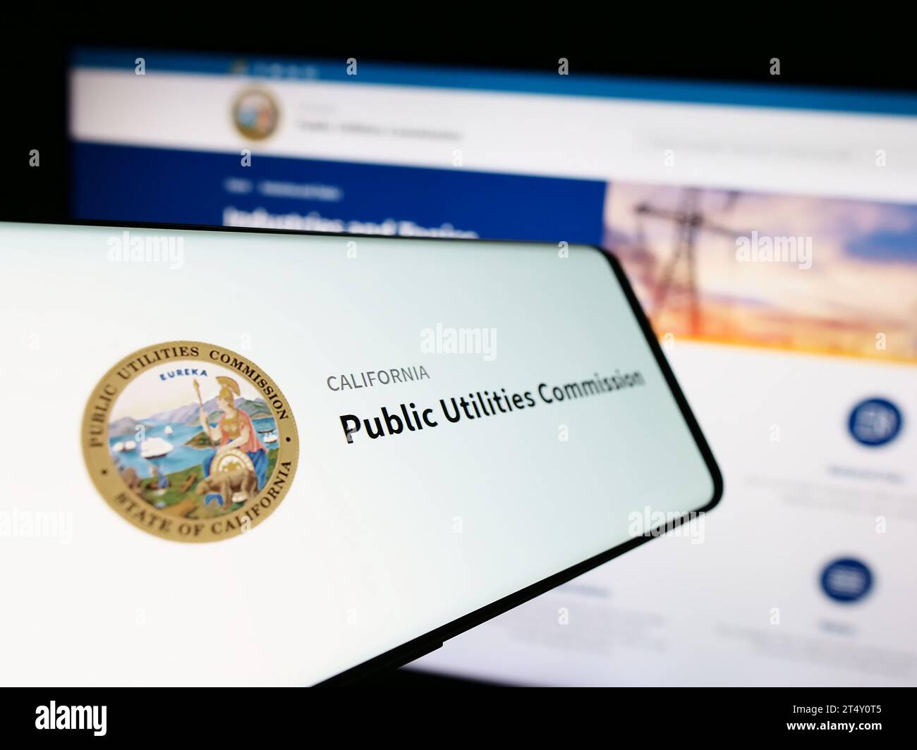 Cellulare con sigillo della California Public Utilities Commission (CPUC) davanti al sito Web aziendale. Mettere a fuoco il display centrale sinistro del telefono. Foto Stock