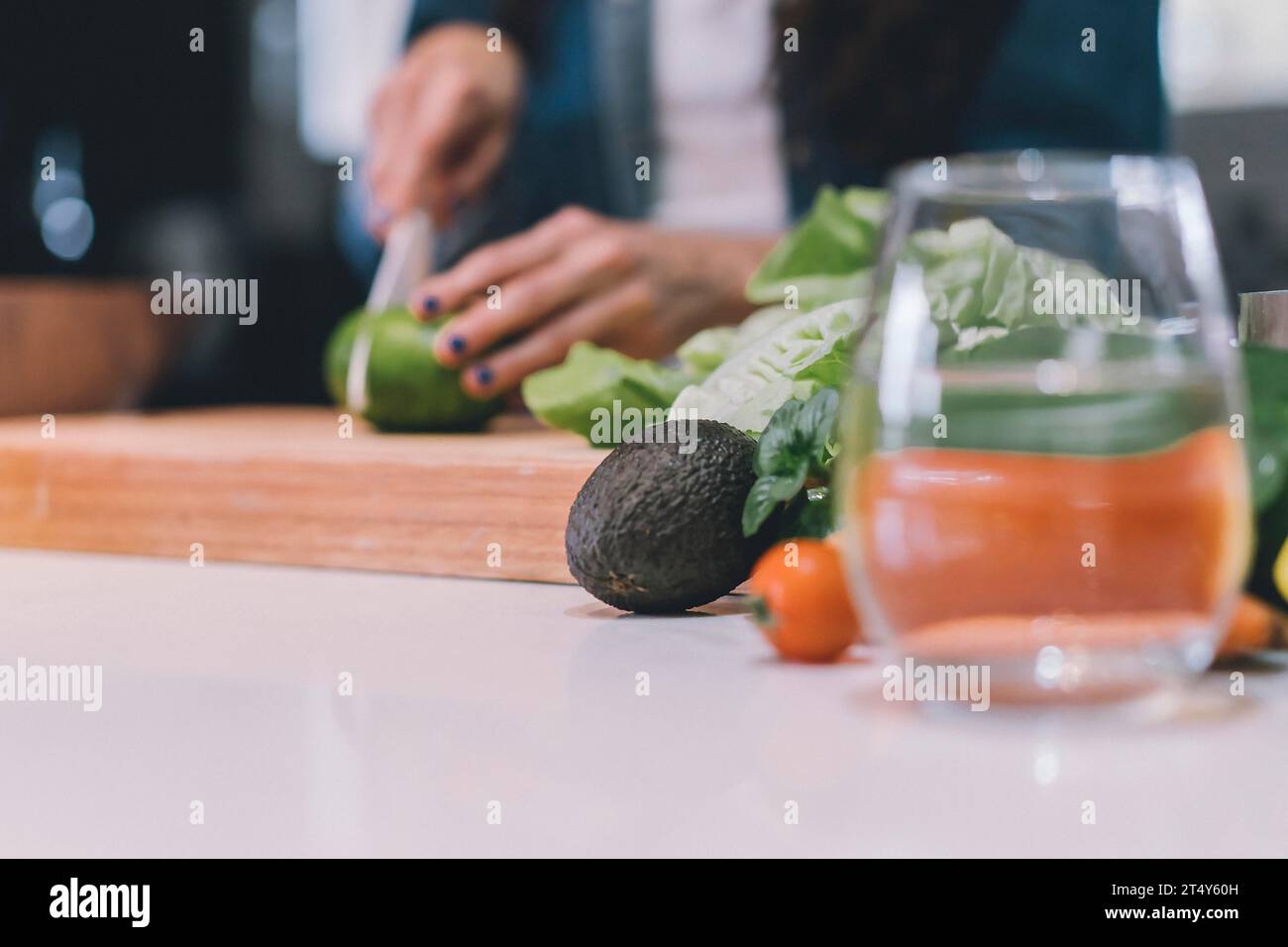 Una donna che trita una verdura nella sua cucina. Copia spazio Foto Stock