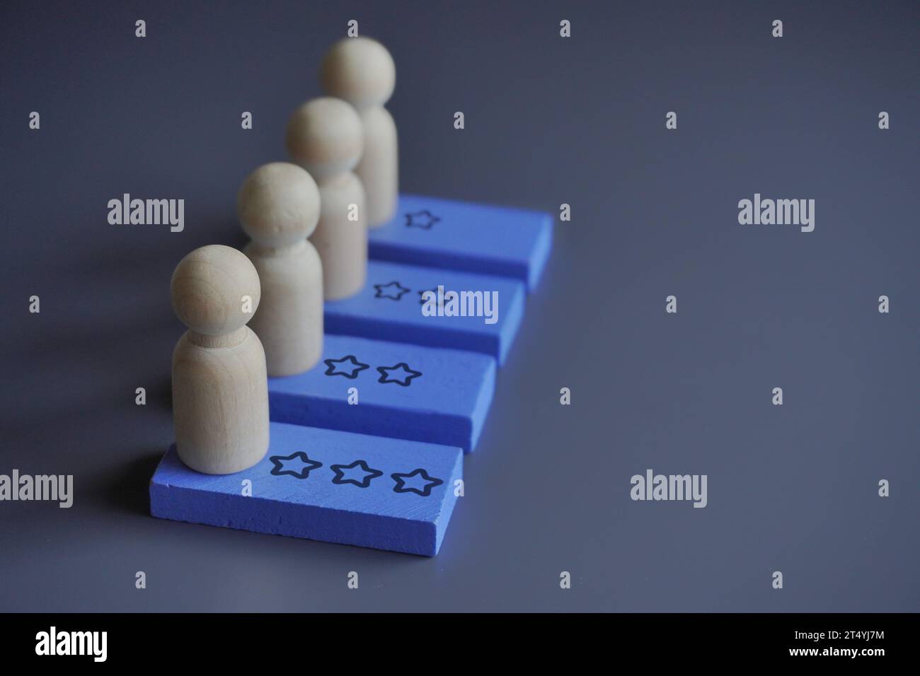 Bambole di legno e icona di revisione a stella. Spazio di copia per il testo. Valutazione dei dipendenti, concetto di performance e progresso Foto Stock