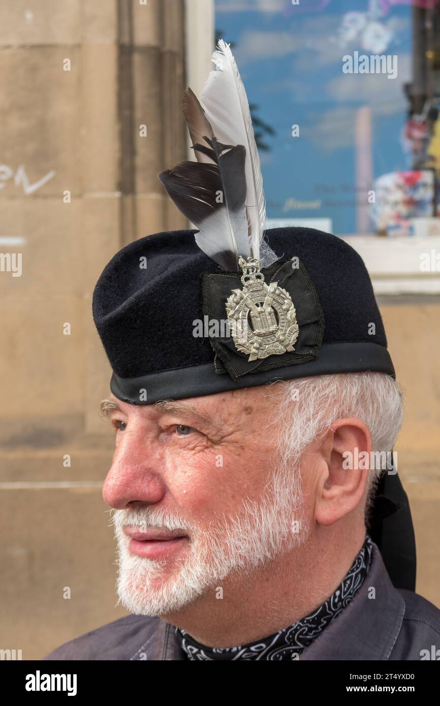 Ritratto ravvicinato di un giocatore di cornamuse, Edimburgo, Scozia, Regno Unito. Il suo cappello presenta un medaglione e piume. Foto Stock