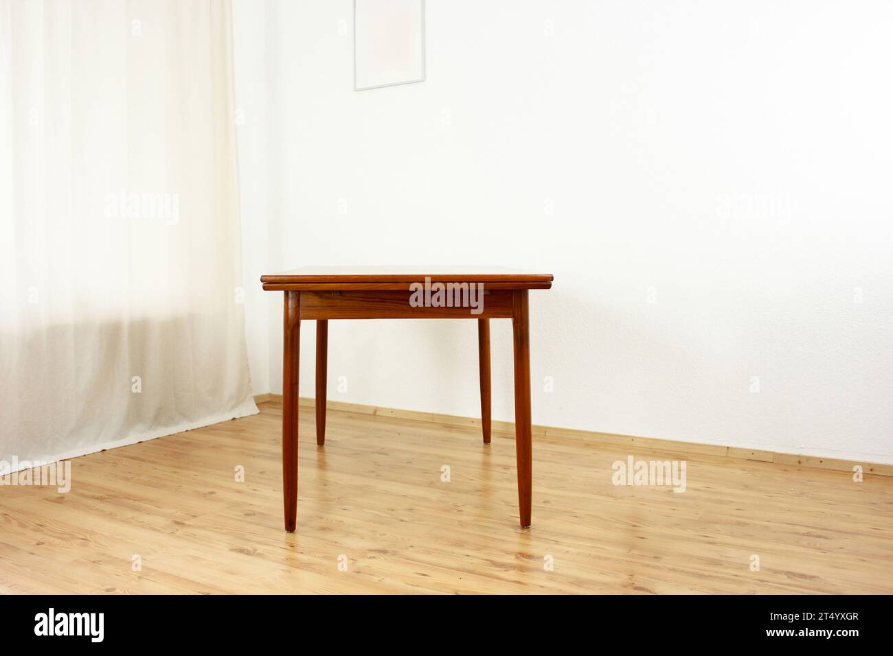 Un tavolo da pranzo in teak della metà del secolo con quattro sedie degli anni '50 '60, design danese, cucina d'epoca, legno massello, antiquariato moderno degli anni '50 e '60 isolato su wal bianco Foto Stock