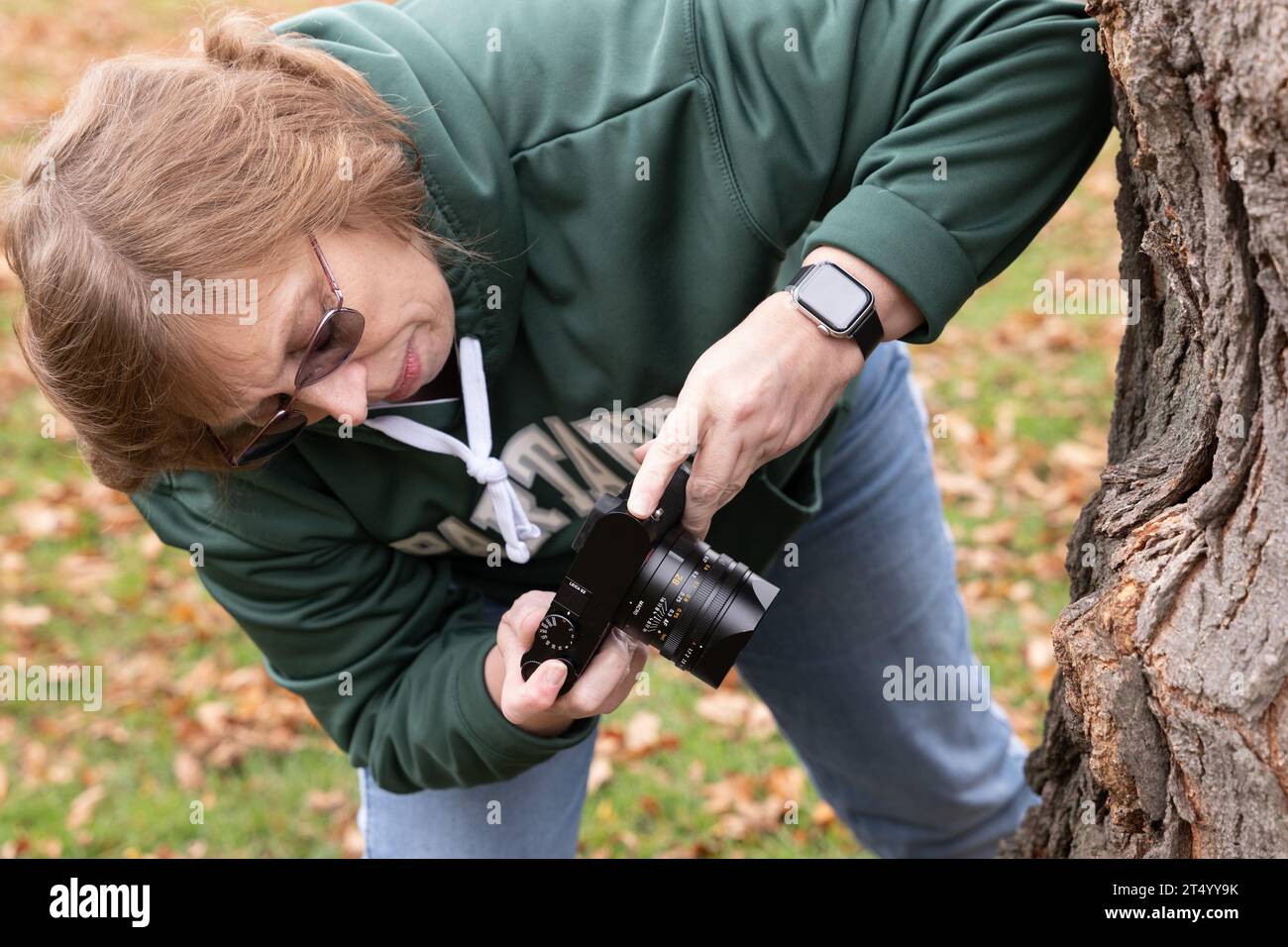 Donna che fa una foto ravvicinata di un albero Foto Stock