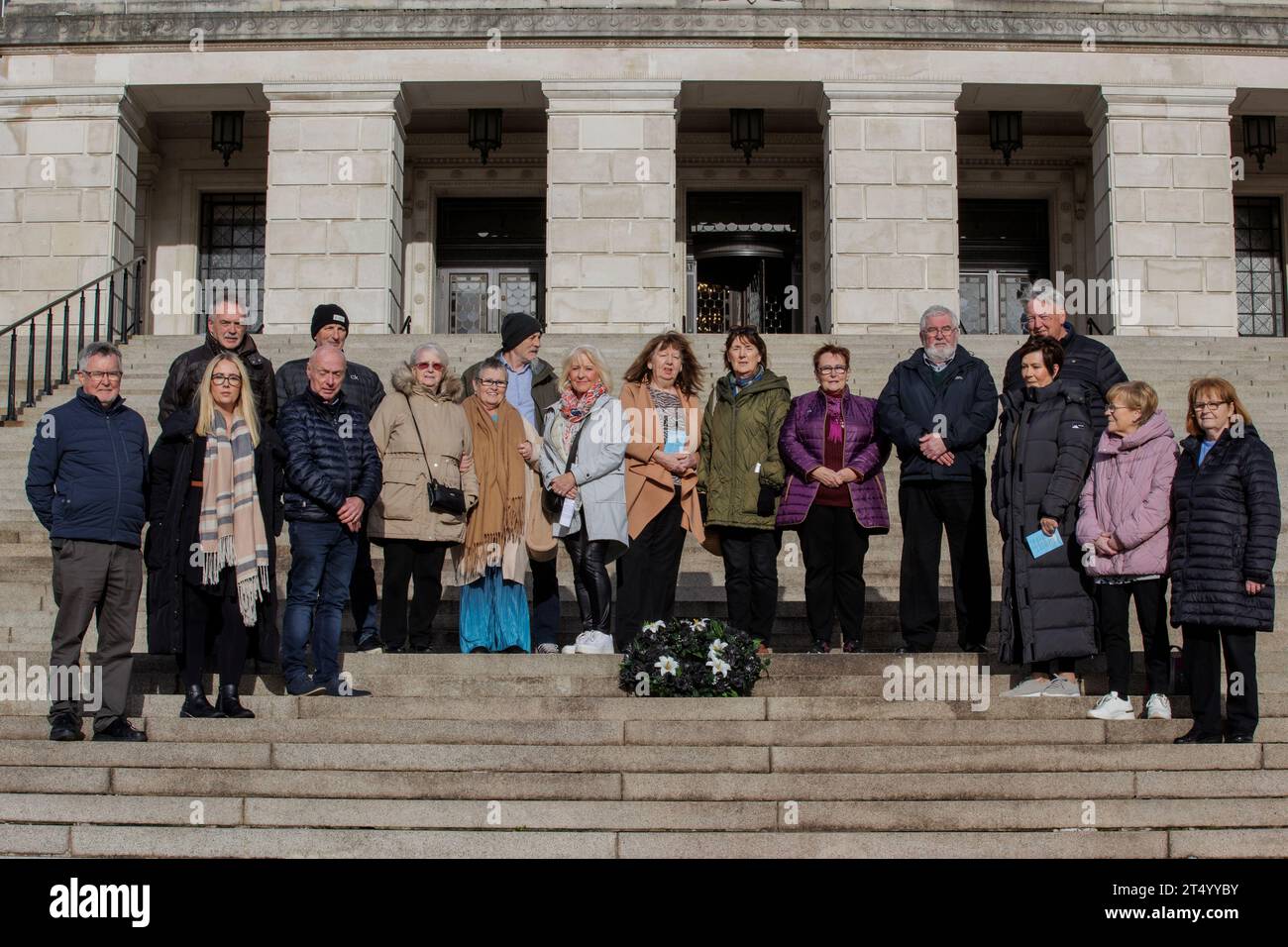 Le famiglie dei dispersi che sono state ritrovate stanno insieme alle famiglie di coloro che sono ancora dispersi sui gradini degli edifici del Parlamento alla 17a marcia annuale All Souls Silent Walk for the Scomparsi a Stormont. I membri delle famiglie dei scomparsi camminano dalla Statua di Carson fino ai gradini degli edifici del Parlamento dove posano una corona nera con cinque gigli bianchi che rappresentano coloro che non sono ancora stati trovati - Joe Lynskey, Columba McVeigh, Robert Nairac, Seamus Maguire e Lisa Dorrian. Data foto: Giovedì 2 novembre 2023. Foto Stock