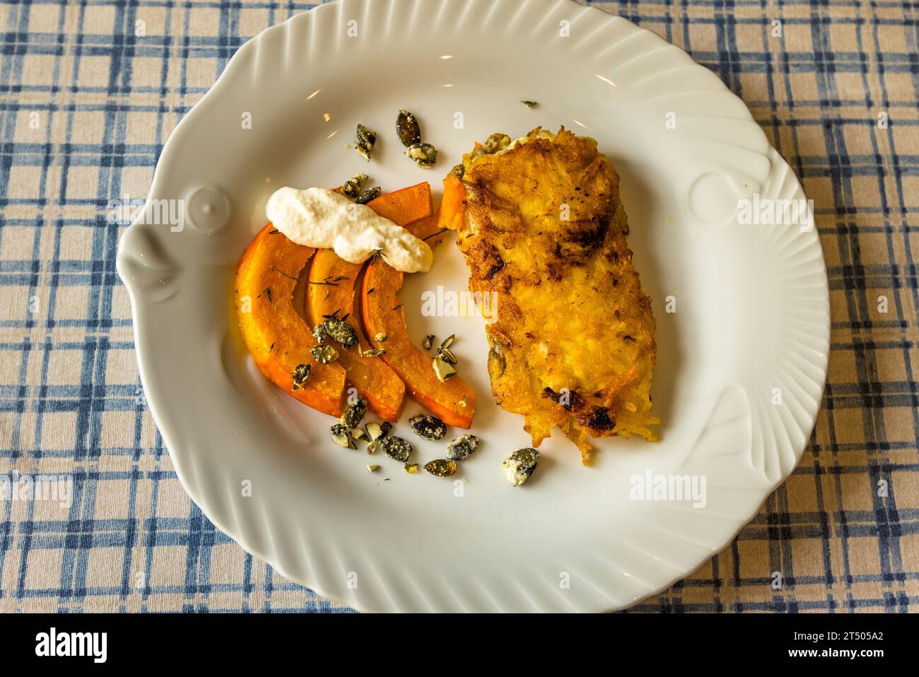 Una variante di carpa presso Fischhof Bächer mostra una crosta di patate arrostite più scura, spicchi di zucca e un cucchiaio di panna acida alle erbe. Da ottobre ad aprile, l'azienda serve piatti di carpa variabili con pesce della propria fattoria. Tirschenreuth, Baviera, Germania. Foto Stock